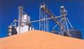 Bulk material pile with machinery and silo.