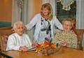 Nursing Home dining room Staff with two residents close up with cornucopia on table